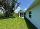 View of backyard featuring a lush lawn and a screened patio area on a sunny day at 8667 Lisa Blvd, North Port, FL 34288