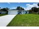 Charming light blue single-story home featuring a lush green lawn and a two-car garage at 8667 Lisa Blvd, North Port, FL 34288
