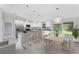 Large island and breakfast bar is surrounded by white cabinets, stainless appliances and dining area at 8687 Lisa Blvd, North Port, FL 34288