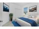 Stylishly decorated bedroom with blue accents and a large picture window bringing in natural light at 8700 Seasalt Loop, Englewood, FL 34224