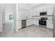 Open kitchen with stainless steel appliances, white cabinets, and tile flooring at 8700 Seasalt Loop, Englewood, FL 34224