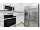 Well-equipped kitchen showcasing stainless steel appliances and white cabinetry at 8700 Seasalt Loop, Englewood, FL 34224