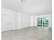 Spacious living room with sliding glass doors, neutral color scheme, and ceramic tile flooring at 8700 Seasalt Loop, Englewood, FL 34224