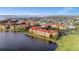 Stunning aerial view of condo community situated on lake with red tile roofs and manicured landscaping at 99 Vivante Blvd # 303, Punta Gorda, FL 33950