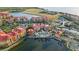 Scenic aerial view of a waterfront condo community featuring lush landscaping, swimming pools, and tennis courts at 99 Vivante Blvd # 303, Punta Gorda, FL 33950