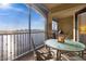 Relaxing screened-in balcony featuring a table and chairs with serene views of the water and landscape at 99 Vivante Blvd # 303, Punta Gorda, FL 33950