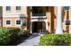 Inviting entrance with brick walkway and lush landscaping to a tan-colored building at 99 Vivante Blvd # 303, Punta Gorda, FL 33950