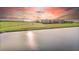 Scenic view of condominium buildings near a pond and green space offering tranquil waterfront living at 99 Vivante Blvd # 303, Punta Gorda, FL 33950
