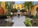 Charming outdoor area with a cozy fireplace surrounded by lush landscaping and comfortable seating at 99 Vivante Blvd # 303, Punta Gorda, FL 33950