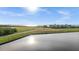 Scenic water view overlooking a lush green field with a resort building in the background on a sunny day at 99 Vivante Blvd # 303, Punta Gorda, FL 33950