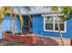Charming blue home with a brick planter, screened entry, and manicured landscaping at 10229 Gulfstream Blvd, Englewood, FL 34224