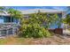 Charming blue home with mature trees and a neatly manicured lawn, complemented by a stack of potting soil at 10229 Gulfstream Blvd, Englewood, FL 34224