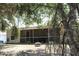 Spacious backyard featuring a screened patio, grill, fire pit, and lush greenery, perfect for outdoor living at 11422 2Nd Ave, Punta Gorda, FL 33955