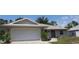 Charming single-story home featuring a two-car garage, neutral siding and metal roof with well manicured landscaping at 11422 2Nd Ave, Punta Gorda, FL 33955