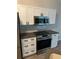 Modern kitchen boasts stainless steel appliances, white cabinetry, and contemporary finishes for a sleek look at 11422 2Nd Ave, Punta Gorda, FL 33955