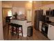 Modern kitchen features stainless steel appliances, breakfast bar with leather stools, and granite countertops at 11422 2Nd Ave, Punta Gorda, FL 33955