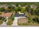 Aerial view of a cozy home featuring a well-maintained lawn and lush, mature trees, offering a serene outdoor living space at 1231 Beacon Dr, Port Charlotte, FL 33952