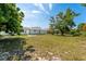 A cozy home featuring a well-maintained backyard, lush trees, offering a serene outdoor living space at 1231 Beacon Dr, Port Charlotte, FL 33952