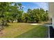 A cozy home featuring a well-maintained backyard, lush trees, offering a serene outdoor living space at 1231 Beacon Dr, Port Charlotte, FL 33952