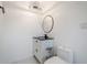 Modern powder room with toilet, white vanity with black countertop, and decorative light fixture at 1231 Beacon Dr, Port Charlotte, FL 33952