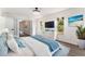 Bright bedroom with large bed, dresser, television, blue accents, and lots of natural light at 1231 Beacon Dr, Port Charlotte, FL 33952