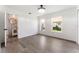 Bright bedroom with two windows and hardwood flooring, leading to a bathroom with a circular mirror and accent wall at 1231 Beacon Dr, Port Charlotte, FL 33952