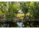 A cozy home featuring a well-maintained lawn and lush, mature trees, offering a serene outdoor living space at 1231 Beacon Dr, Port Charlotte, FL 33952