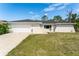 Charming single-story home featuring a two-car garage, manicured lawn, and freshly painted exterior at 1231 Beacon Dr, Port Charlotte, FL 33952