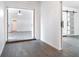 Hallway featuring gray wood floors and a white barn door with framed glass panels leading to adjacent rooms at 1231 Beacon Dr, Port Charlotte, FL 33952