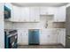 Modern kitchen featuring white cabinets, stainless steel appliances, and stylish tile backsplash at 1231 Beacon Dr, Port Charlotte, FL 33952