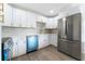 Modern kitchen with stainless steel appliances, custom cabinets, and a stylish backsplash over a farmhouse sink at 1231 Beacon Dr, Port Charlotte, FL 33952