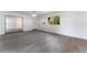 Spacious living area featuring gray wood floors, sliding doors, and ample natural light at 1231 Beacon Dr, Port Charlotte, FL 33952