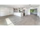 Open-concept living space with modern lighting and stylish flooring, seamlessly connecting to the kitchen at 1231 Beacon Dr, Port Charlotte, FL 33952