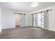 Spacious living room with gray floors, white walls, barn doors, and a decorative ceiling light at 1231 Beacon Dr, Port Charlotte, FL 33952