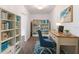 Inviting home office with custom shelving, hardwood floors, beach decor and a plush blue chair at 1231 Beacon Dr, Port Charlotte, FL 33952