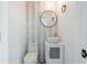 Stylish powder room with a vessel sink, mosaic tile accent wall, round mirror, and patterned tile floor at 1231 Beacon Dr, Port Charlotte, FL 33952