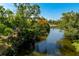 Serene water view featuring lush, mature trees reflecting in the river at 1231 Beacon Dr, Port Charlotte, FL 33952