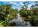 Serene water view featuring lush, mature trees reflecting in the river at 1231 Beacon Dr, Port Charlotte, FL 33952
