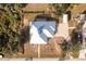 Stunning aerial view of a home with a modern metal roof, screened-in lanai, and spacious driveway at 13204 Kakapo Ave, Port Charlotte, FL 33981