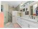 Bright bathroom with double vanities, stylish fixtures, and a walk-in shower with tile surround at 13204 Kakapo Ave, Port Charlotte, FL 33981