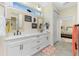 Elegant bathroom featuring double vanity sinks, decorative mirrors, and a glimpse into the bedroom at 13204 Kakapo Ave, Port Charlotte, FL 33981
