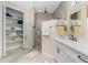 Well-lit bathroom featuring a double vanity, walk-in shower with glass door, and built-in linen storage at 13204 Kakapo Ave, Port Charlotte, FL 33981