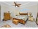 Comfortable bedroom featuring tropical bed, tray ceiling, bright light, and wood-look flooring at 13204 Kakapo Ave, Port Charlotte, FL 33981