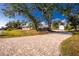 Long paved driveway leading to a charming home with mature trees at 13204 Kakapo Ave, Port Charlotte, FL 33981