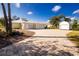 Charming yellow home featuring a three-car garage, brick driveway, and a separate storage shed at 13204 Kakapo Ave, Port Charlotte, FL 33981