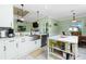 Bright kitchen with island and view to the breakfast nook with screened patio at 13204 Kakapo Ave, Port Charlotte, FL 33981
