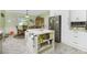 Bright kitchen with a marble top island, stainless steel appliances, white cabinets, and an adjacent dining area at 13204 Kakapo Ave, Port Charlotte, FL 33981