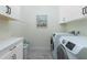 Functional laundry room with modern washer and dryer, ample cabinet space, and stylish flooring at 13204 Kakapo Ave, Port Charlotte, FL 33981