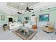 Bright living room with ceiling fans, whitewashed wood floors, and coastal decor at 13204 Kakapo Ave, Port Charlotte, FL 33981