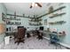 Well-lit office with dual work stations, custom wood shelving, and a ceiling fan at 13204 Kakapo Ave, Port Charlotte, FL 33981